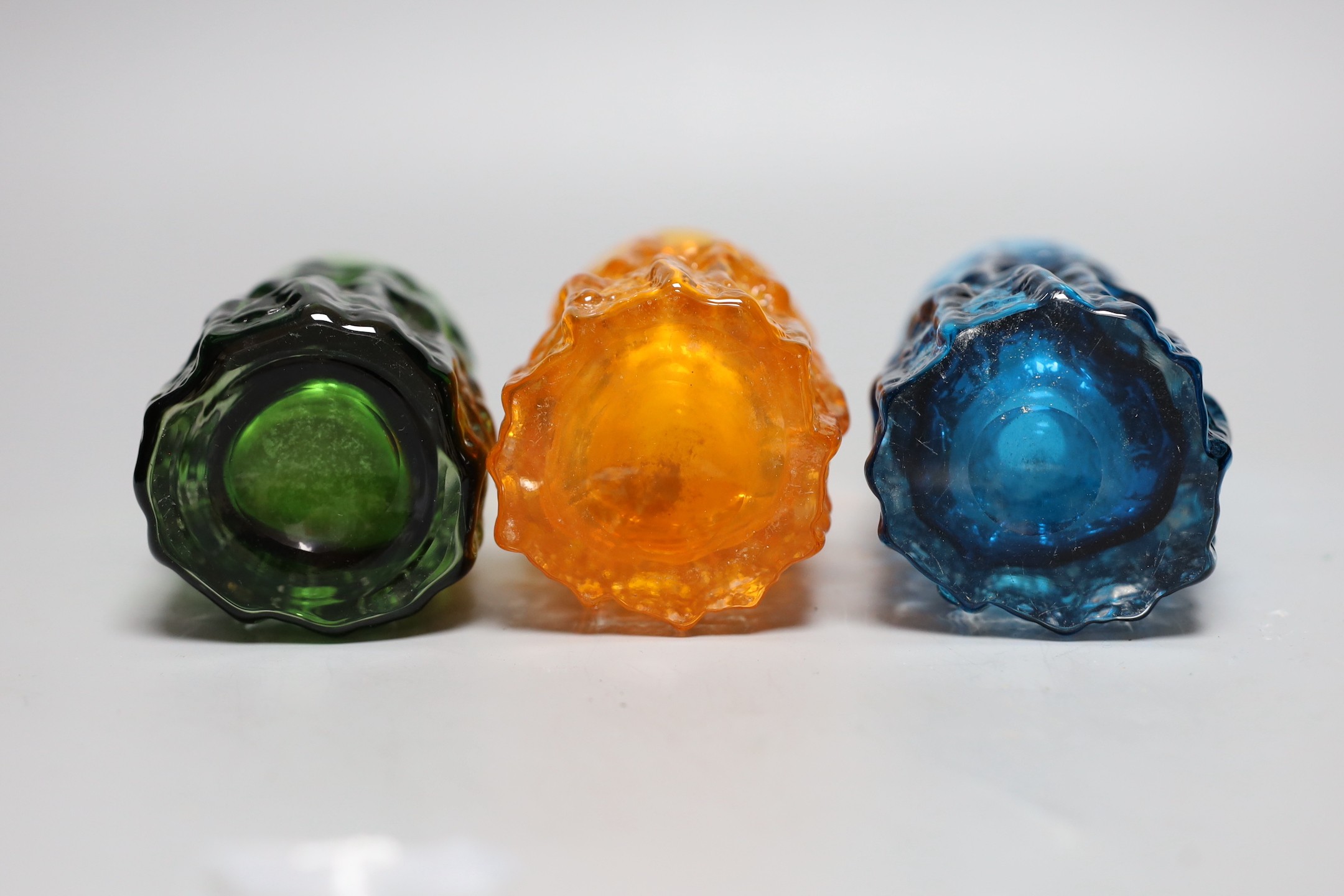 Three Whitefriars 'bark' cylinder vases, model 9689 designed by Geoffrey Baxter, kingfisher blue, tangerine and green glass, each 15cm high.